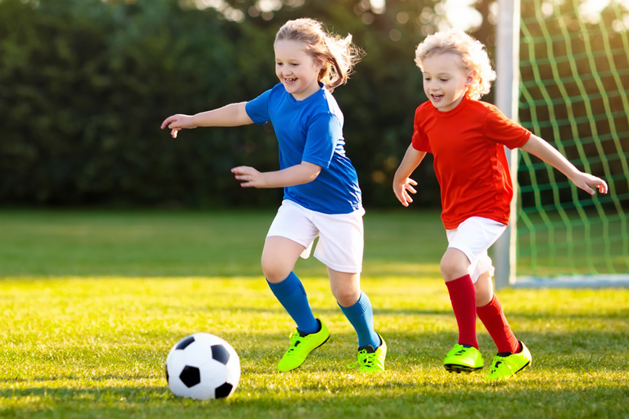 Two young kids playing soccer